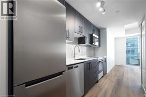 Kitchener condo for rent - A modern kitchen with stainless steel appliances and wooden floors.