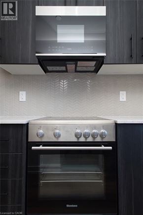 Kitchener condo for rent - A modern kitchen with a black oven and wooden cabinets.