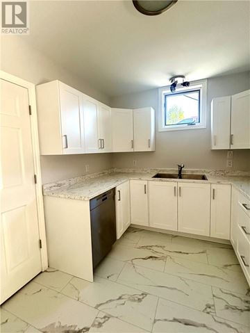 Sudbury apartment for rent - A kitchen with white cabinets and marble flooring.