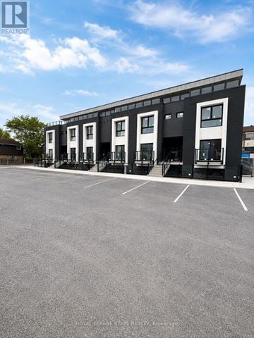 Niagara Falls (Oldfield) townhouse for rent - A parking lot in front of a building with a sign that says REALTOR.