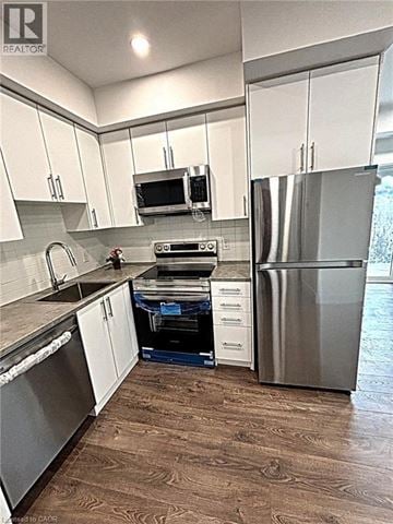 Niagara Falls townhouse for rent - A kitchen with white cabinets and a stainless steel refrigerator.