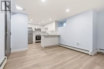 Hamilton (St. Clair) apartment for rent - A spacious kitchen with white cabinets and a wooden floor.