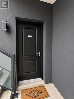 Niagara Falls (Oldfield) townhouse for rent - A black door with a glass window on the left and a doormat that says "Welcome" on the right.
