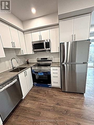Niagara Falls (Oldfield) townhouse for rent - A kitchen with white cabinets and a wood floor.