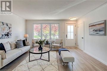London East (East C) apartment for rent - A well-lit living room with a white sofa, a glass table, and a painting on the wall.