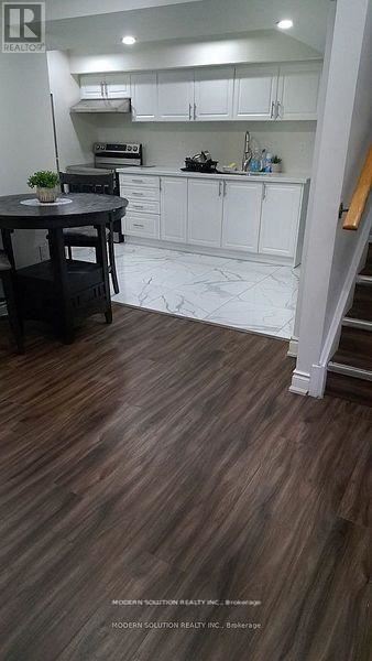 Brampton (Credit Valley) apartment for rent - A kitchen with white cabinets and a wooden floor.