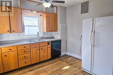 Meaford apartment for rent - A kitchen with wooden cabinets and a white fridge.