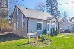 Meaford apartment for rent - A small house with a grey roof and a red flag in front of it.