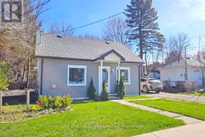 Meaford apartment for rent - A small house with a grey exterior and a small front yard.
