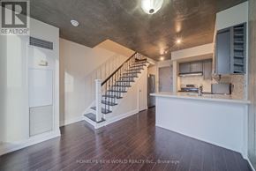 Toronto (Niagara) condo for rent - A spacious living room with a staircase leading to the upper floor.