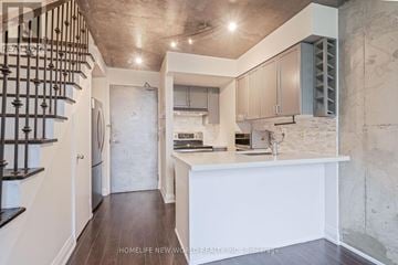 Toronto (Niagara) condo for rent - A modern kitchen with a staircase on the left side.