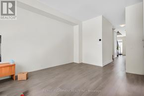 Thorold (Hurricane/Merrittville) apartment for rent - A room with a wooden floor and white walls, with a small table and a box on the floor.