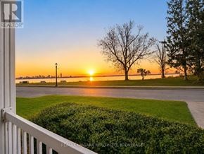 Fort Erie (Lakeshore) apartment for rent - A sunset view from a balcony with a hedge in the foreground.