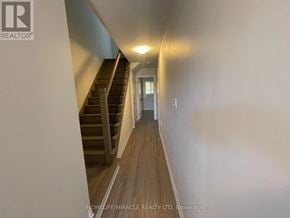Cambridge townhouse for rent - A hallway with a staircase and a door at the end.