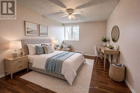 London East (East D) condo for rent - A well-lit bedroom with a large bed, a desk, and a chair.