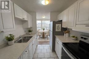 London East (East D) condo for rent - A kitchen with white cabinets and a black stove top oven.