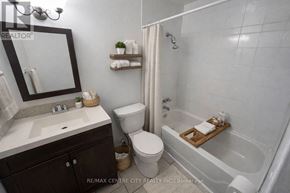 London East (East D) condo for rent - A bathroom with a toilet, sink, and bathtub.