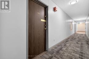 Toronto (Kingsview Village-The Westway) condo for rent - A hallway with a brown door and carpeted floor.