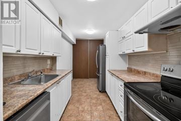 Toronto (Kingsview Village-The Westway) condo for rent - A kitchen with white cabinets and brown tiled flooring.