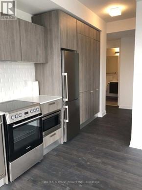 Toronto (Church-Yonge Corridor) condo for rent - A modern kitchen with dark wood floors and stainless steel appliances.