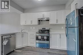 Oshawa (Donevan) duplex for rent - A kitchen with white cabinets and a black fridge.