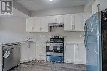 Oshawa (Donevan) duplex for rent - A kitchen with white cabinets and a black fridge.