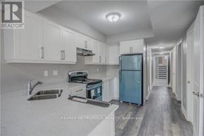 Oshawa (Donevan) duplex for rent - A kitchen with white cabinets and a blue refrigerator.