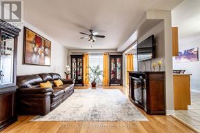 St. Catharines (Rykert/Vansickle) apartment for rent - A living room with a brown leather couch and a flat screen TV mounted on the wall.