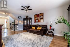 St. Catharines (Rykert/Vansickle) apartment for rent - A living room with a brown leather couch and a ceiling fan.