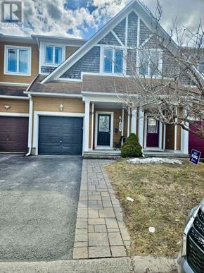 Ottawa townhouse for rent - A house with a garage and a driveway in front.