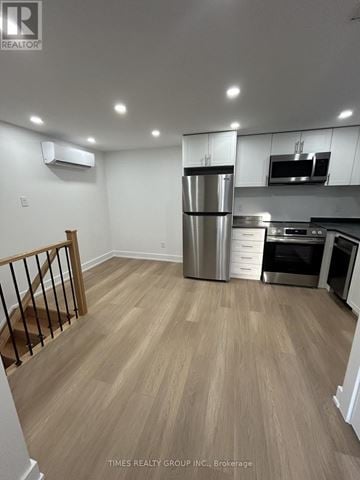 Toronto (South Riverdale) triplex for rent - A kitchen with a refrigerator, microwave, and oven.