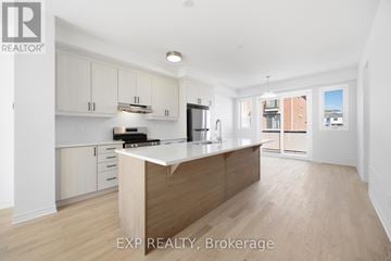 Markham townhouse for rent - A kitchen with white cabinets and a wooden island.