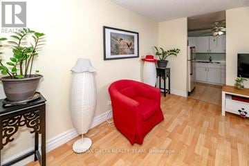 Ottawa condo for rent - A living room with a red chair and a plant on the side table.
