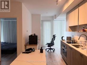 Toronto (Willowdale East) condo for rent - A modern kitchen with a desk and a bed in the same room.