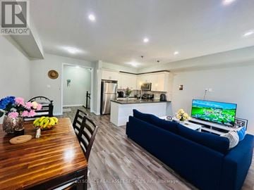 Hamilton (Waterdown) townhouse for rent - A living room with a blue couch and a television on a stand.