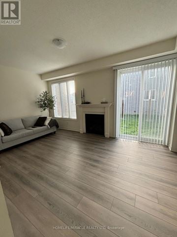 Brampton (Northwest Brampton) townhouse for rent - A living room with a grey sofa and a fireplace.