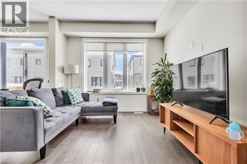 Thorold apartment for rent - A modern living room with a grey couch and a wooden TV stand.