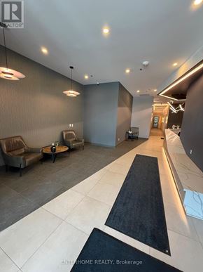 Kitchener condo for rent - A modern lobby area with a black and white carpet leading to a hallway.