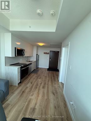 Kitchener condo for rent - A real estate listing photo of a small apartment with a kitchenette and a single bed.
