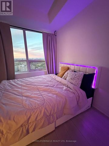 Mississauga (Fairview) condo for rent - A bedroom with a large bed and a window overlooking a cityscape.