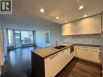 Vancouver apartment for rent - A modern kitchen with white cabinets and a marble backsplash.