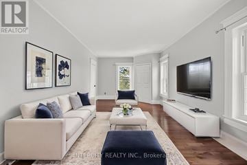 Erin apartment for rent - A living room with a white couch and a television on the wall.