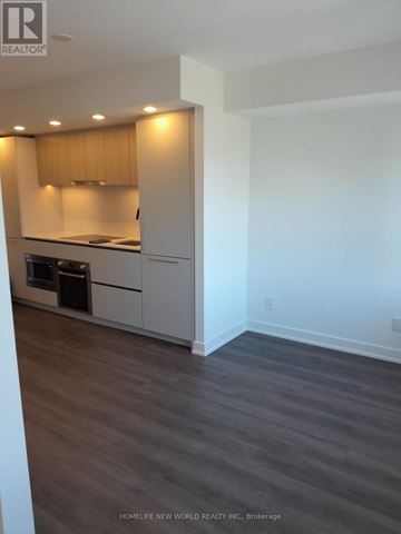 Toronto (North St. James Town) condo for rent - A kitchen with white cabinets and a wooden backsplash.