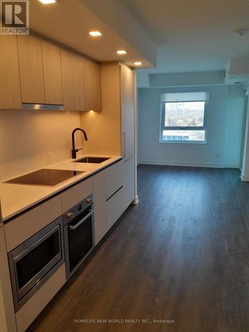 Toronto (North St. James Town) condo for rent - A kitchen with wooden cabinets and a window.