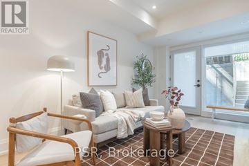 Toronto (South Riverdale) multi-family for rent - A living room with a couch, a chair, a table, and a painting on the wall.