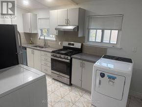 Toronto (West Humber-Clairville) apartment for rent - A white washing machine is in a kitchen with white cabinets.