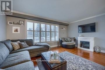 Brampton (Brampton East) apartment for rent - A living room with a grey couch and a white fireplace.