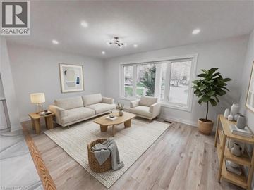 Kitchener apartment for rent - A well-lit living room with a large sofa, a coffee table, and a potted plant.