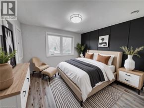 Kitchener apartment for rent - A bedroom with a large bed, a chair, and a nightstand.