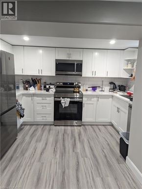 Kitchener apartment for rent - A garage with a broom and a blue container.